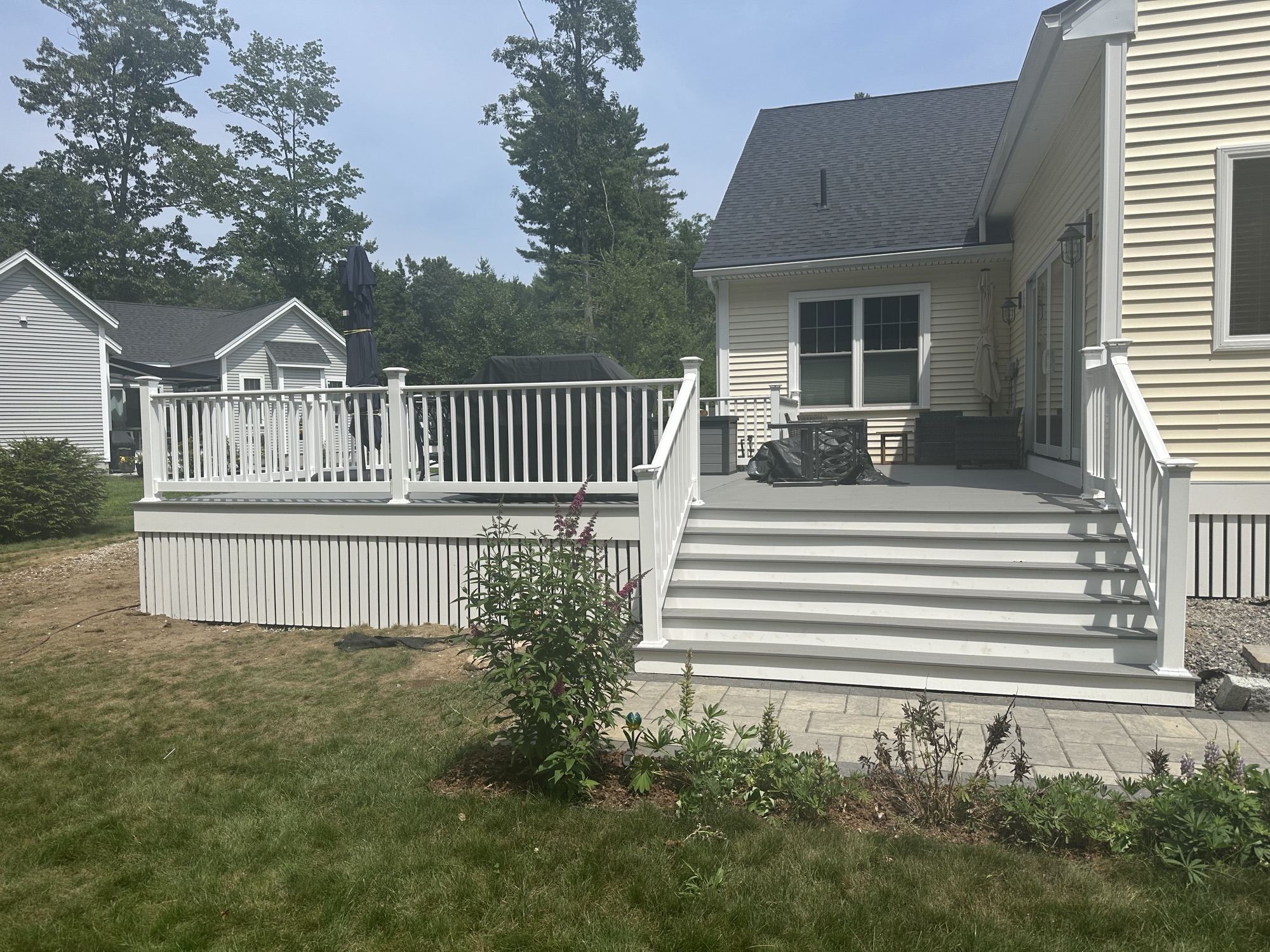Composite deck and paver patio on a finished home in Wells, Maine