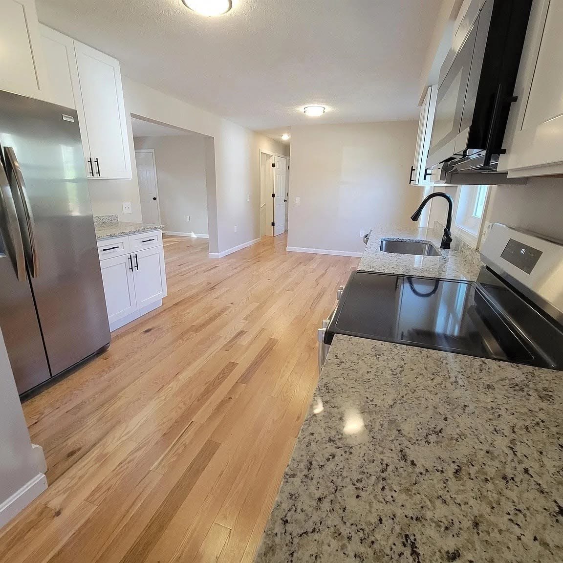 Remodeled kitchen with granite counters and new hardwood flooring
