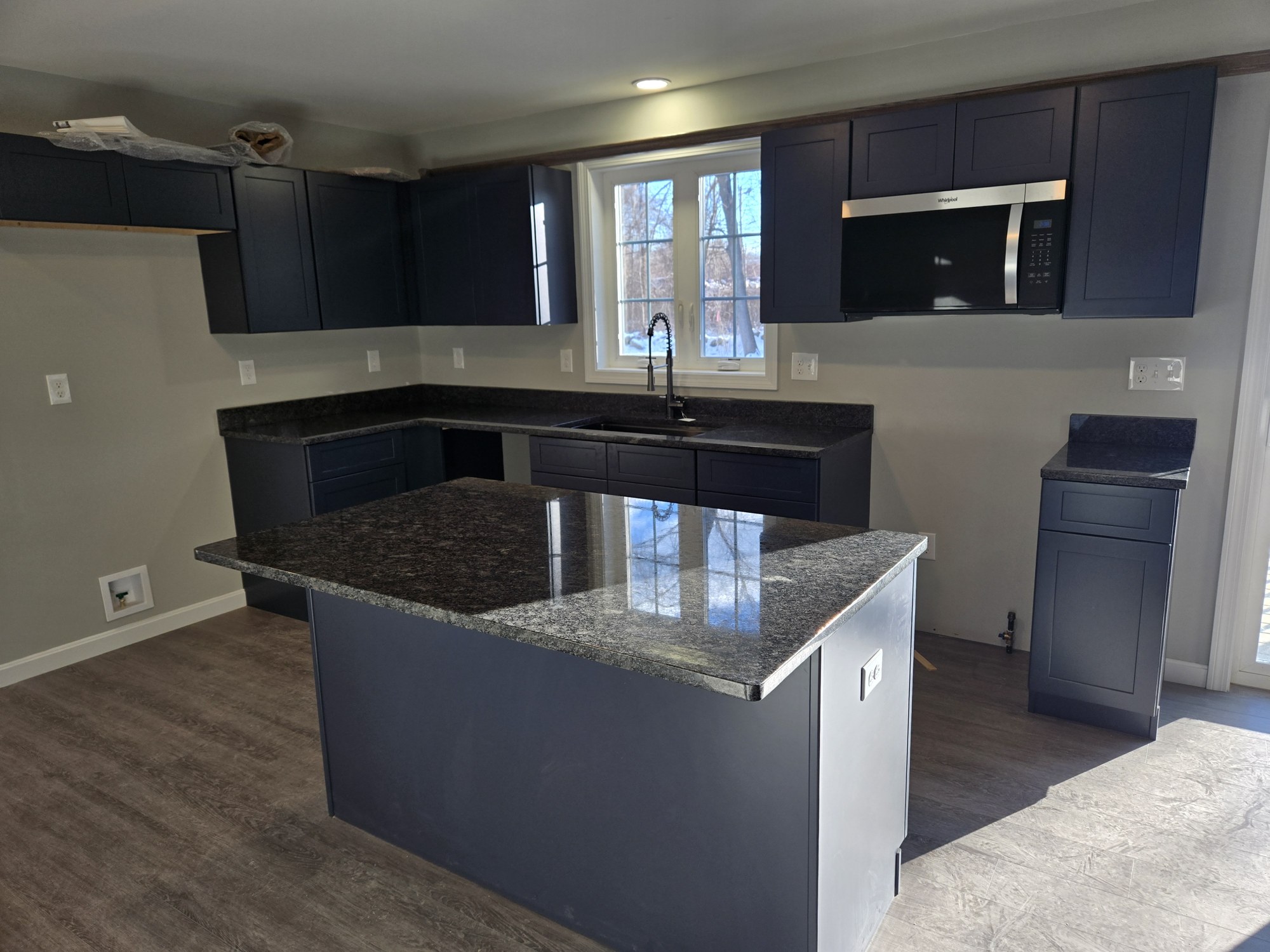 Kitchen with charcoal cabinets and a granite-topped island