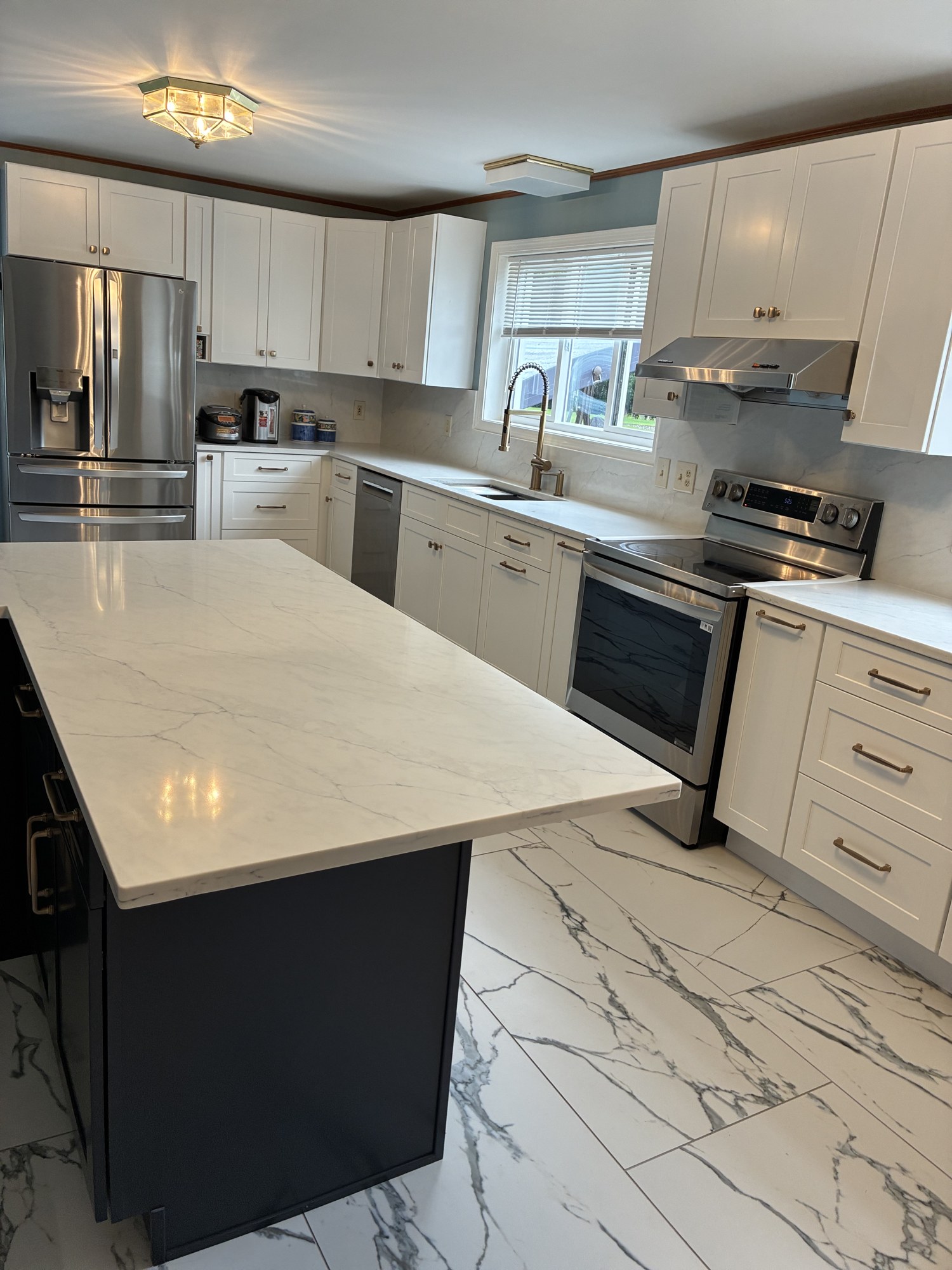 Large-format tile floor running under a full kitchen remodel