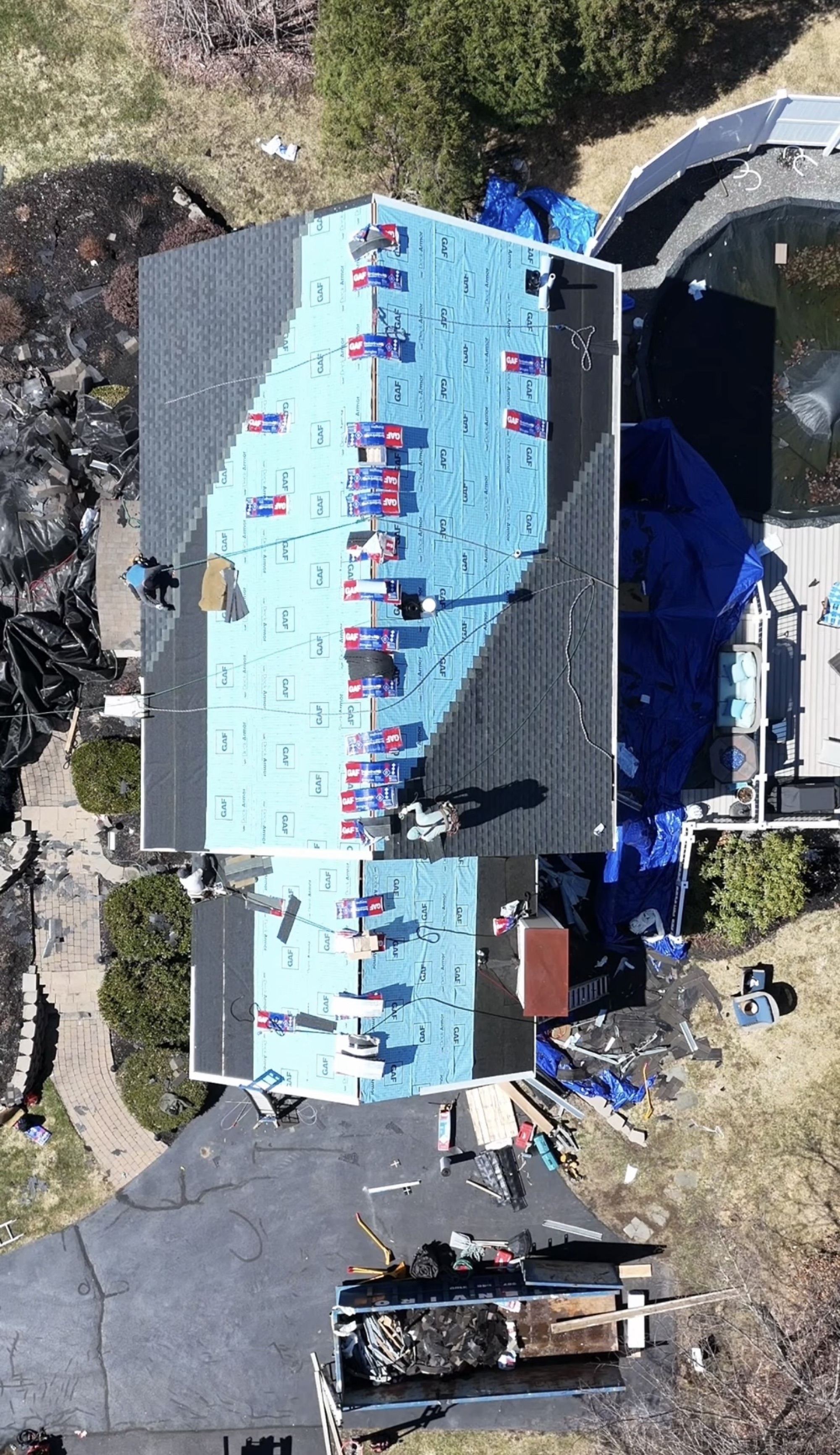 Aerial view of a roof deck covered in underlayment before shingles